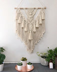 Hand-woven pendant home decor hanging on white background.