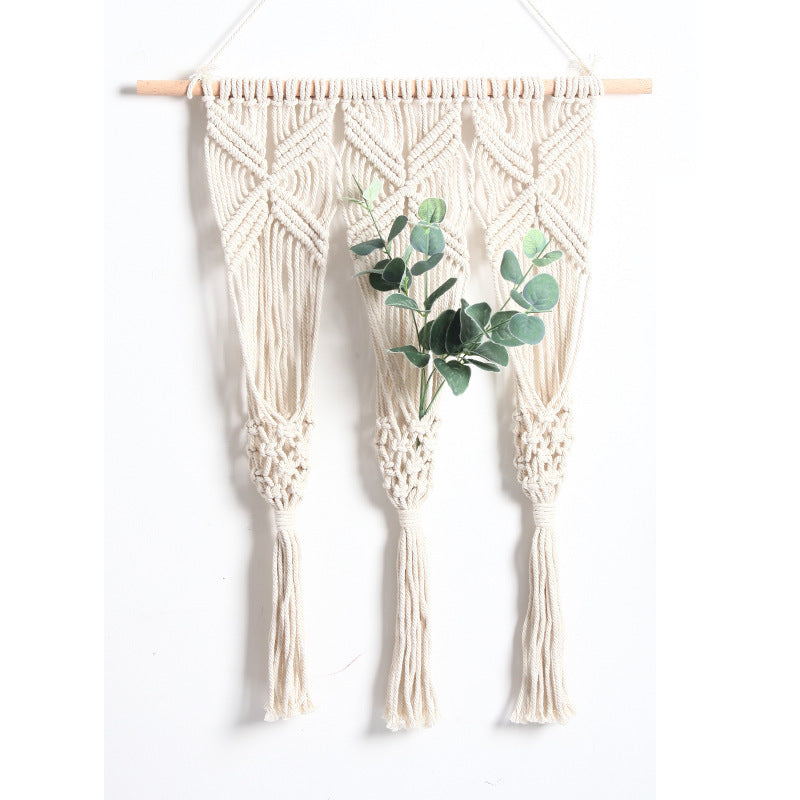 A vertical shot of the macramé tapestry hanging naturally from a wooden dowel. A small, rustic terracotta or ceramic pot should be placed inside the rack with a few stems of dried pampas grass or lavender.