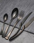 Matte black stainless steel cutlery set on white background.