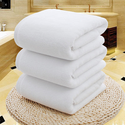 The towel is tightly rolled to show its thickness, with the outer edge slightly unfurled to reveal the plush terry cloth texture.